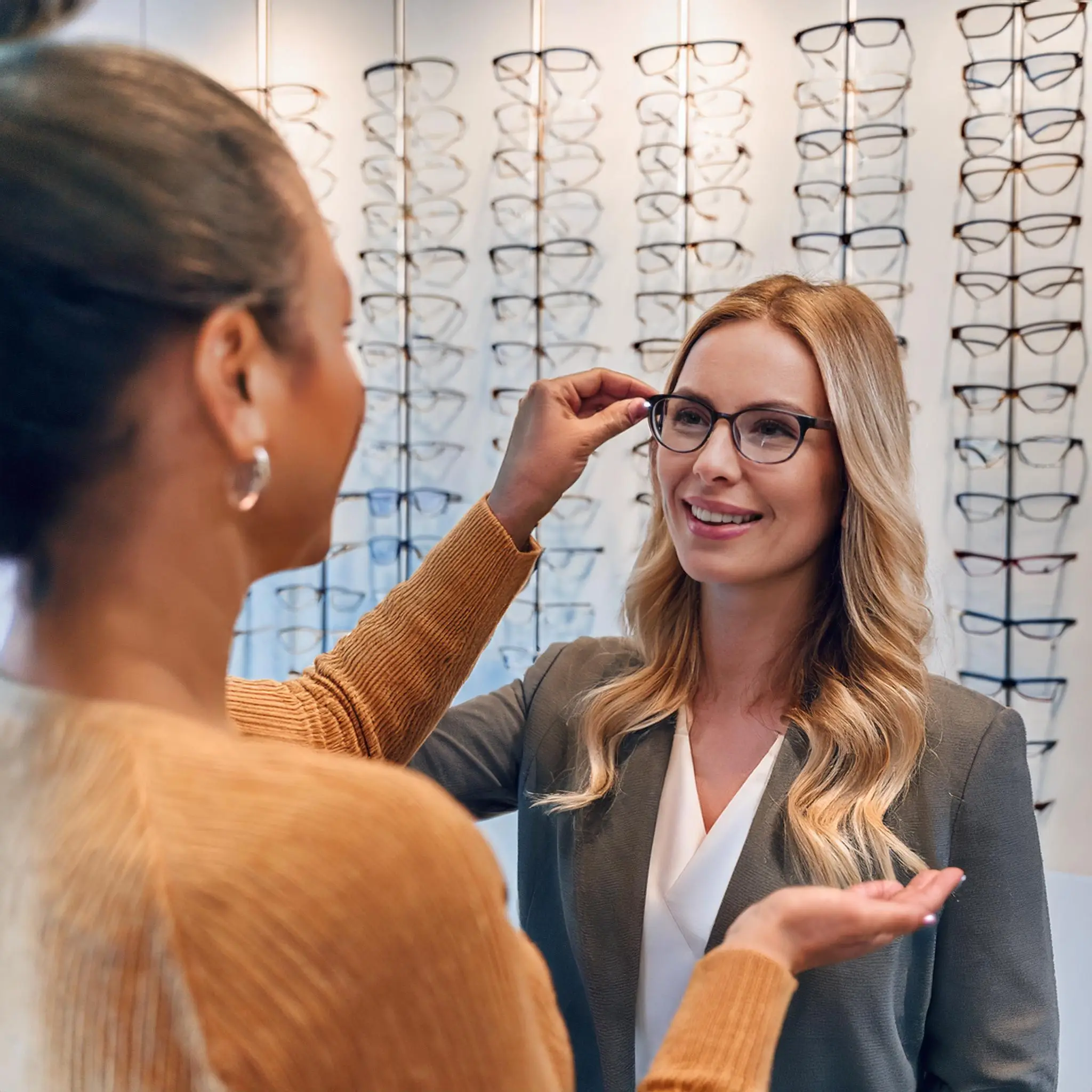 Firefly A happy customer trying on a pair of fashionable reading glasses while receiving guidance f Reading Glasses in Waterloo