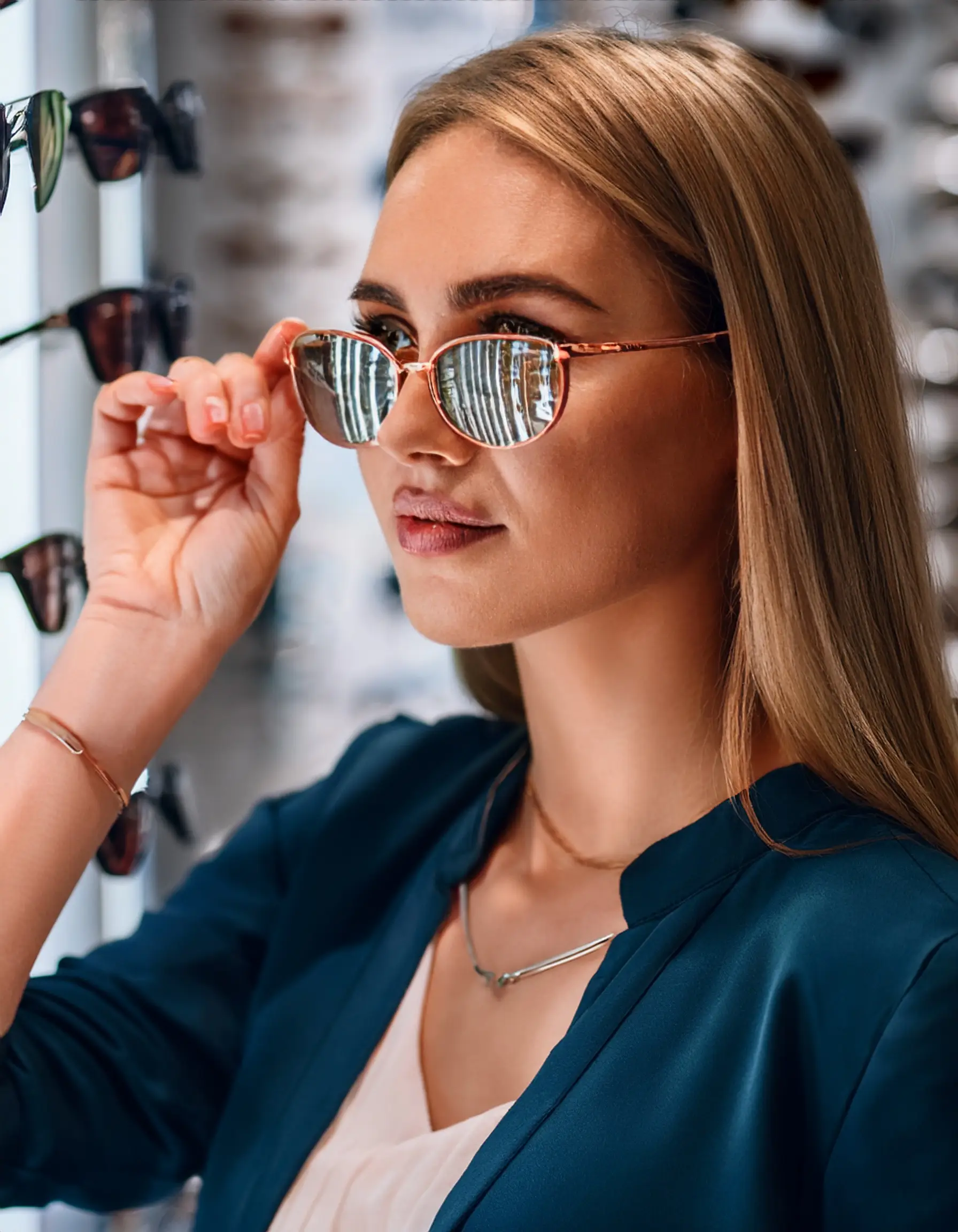 Firefly A young woman trying on different designer prescription sunglasses in an upscale optical bou Premier Prescription Sunglasses in Waterloo